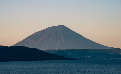 Scenic view of sea against mountain during sunset