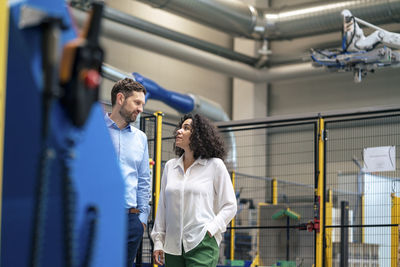 Businesswoman discussing with businessman at industry