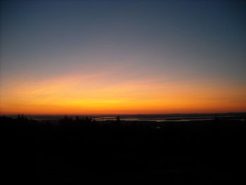 Scenic view of silhouette landscape against orange sky