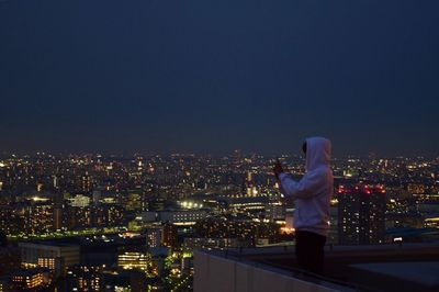 Illuminated cityscape against clear sky at night