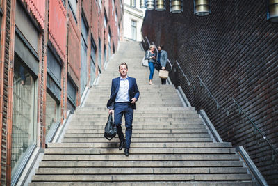 Portrait of mature businessman climbing steps