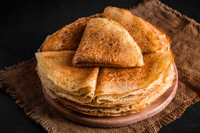 A stack of delicious pancakes on a black background. food for the holiday maslenitsa. 