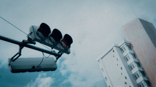 Low angle view of road signal against sky during winter