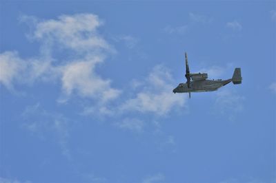 Low angle view of airplane flying against blue sky