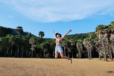 Full length of woman jumping against sky