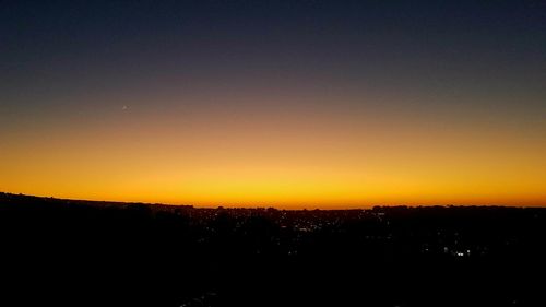 Silhouette landscape against clear sky at night