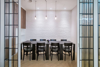 Empty chairs and tables in illuminated room