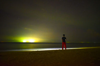 Rear view of silhouette man standing on beach