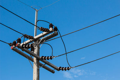 Low angle view of communications tower against blue sky