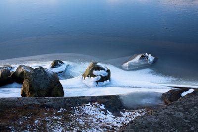 High angle view of rocks on sea shore during winter