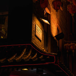 Low angle view of illuminated lanterns hanging in old building