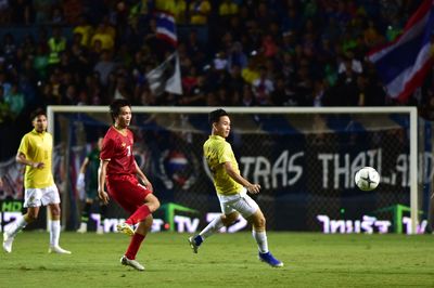 Group of people playing soccer on field