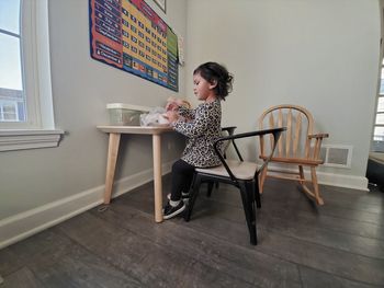 Side view of woman sitting on table