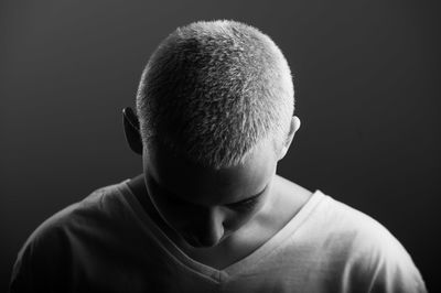 Close-up portrait of boy against black background