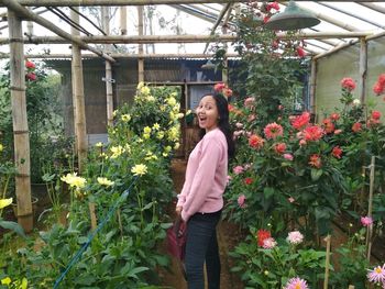 Portrait of woman standing in greenhouse