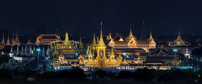 Illuminated buildings against sky at night