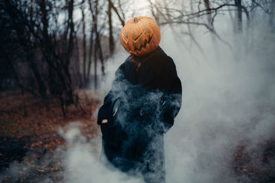 Halloween pumpkin head with scary face outdoors