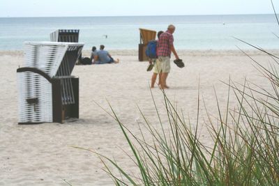 Rear view of people walking on beach