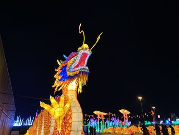 Low angle view of illuminated statue against sky at night