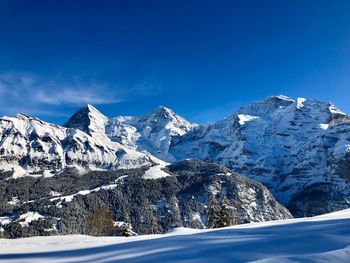 Snowcapped mountains against blue sky