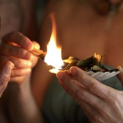 Close-up of hands holding burning candles