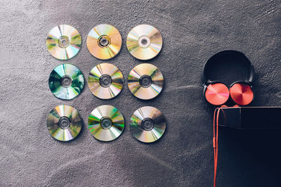 Compact discs decorated over wall by headphones on shelf