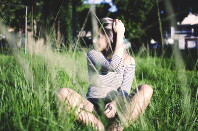 Woman sitting on grass in field