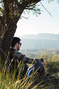 Side view of young man looking at mountains