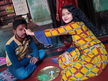 Portrait of smiling young couple sitting outdoors