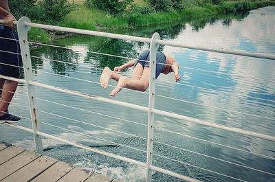 Woman jumping in boat on lake