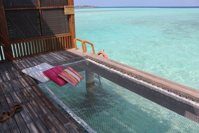 This was taken of a hammock sitting on top of the water at the four seasons resort in the maldives
