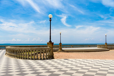 Street light by sea against sky