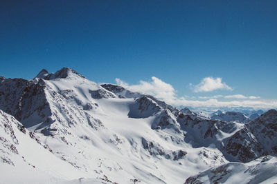 Scenic view of snowcapped mountains against blue sky