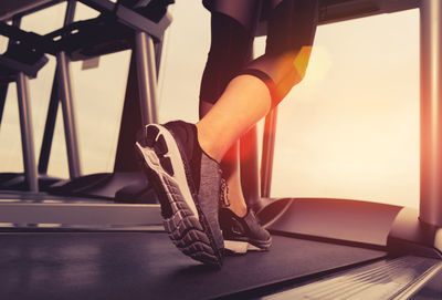 Low section of woman walking on treadmill