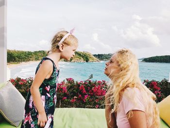 Woman with arms raised against sky