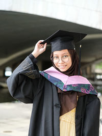 Portrait of woman wearing graduation gown