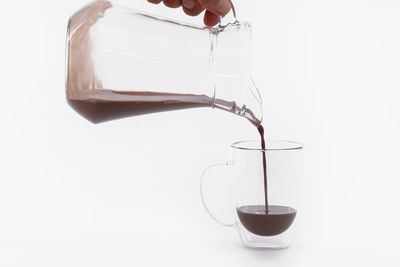 Close-up of coffee pouring over white background