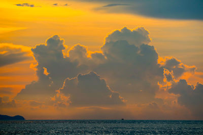 Sunset orange cloud back on dark silhouette sky and ship on sea background