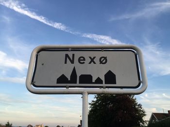 Low angle view of road sign against cloudy sky