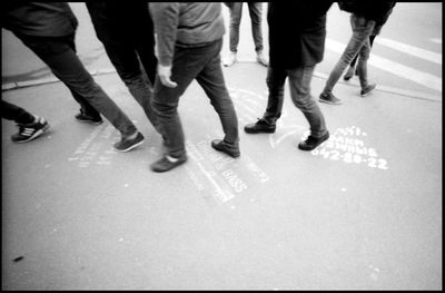 Low section of people walking on city street