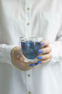 Midsection of woman holding drinking glass