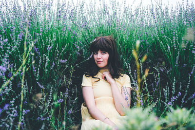 Portrait of beautiful young woman standing on field