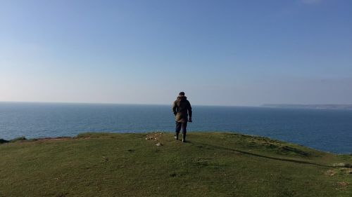 Full length of man standing on sea against clear sky