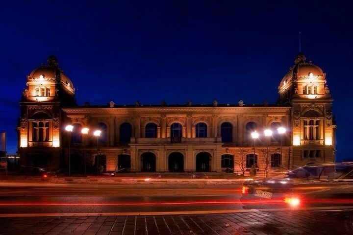 illuminated, night, architecture, built structure, building exterior, light trail, long exposure, motion, transportation, blurred motion, speed, travel destinations, city, clear sky, road, street, famous place, travel, city life, sky