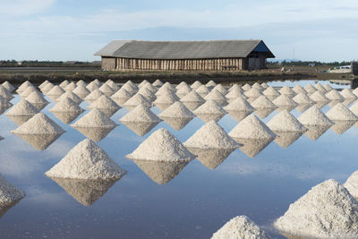 Salt heap on lake with house in background