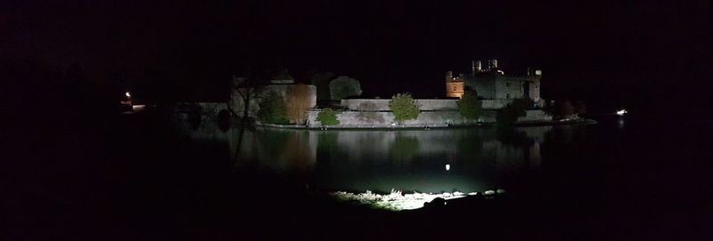Reflection of illuminated building in water at night