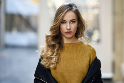 Portrait of beautiful young woman standing in city