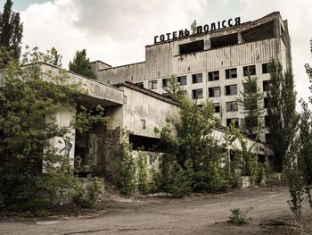 Abandoned building by road against sky