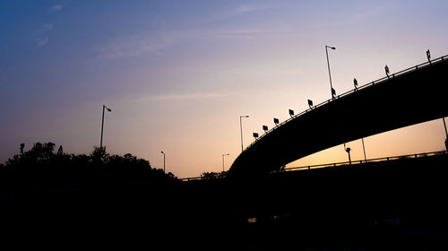 Silhouette bridge against sky during sunset