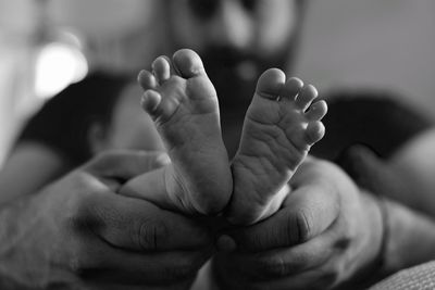 Close-up of father holding baby feet